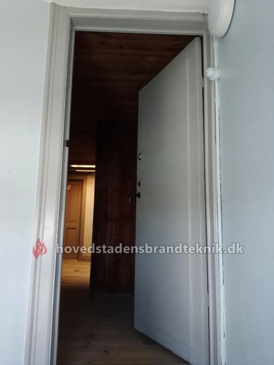 Åben hvid dør ved bagtrappen på 5. sal