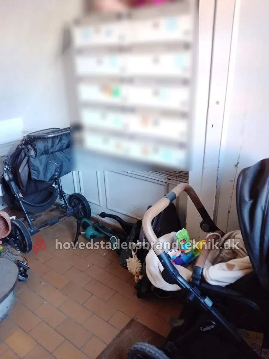 To barnevogne og en løbecykel ved postkasserne i stueetagen
