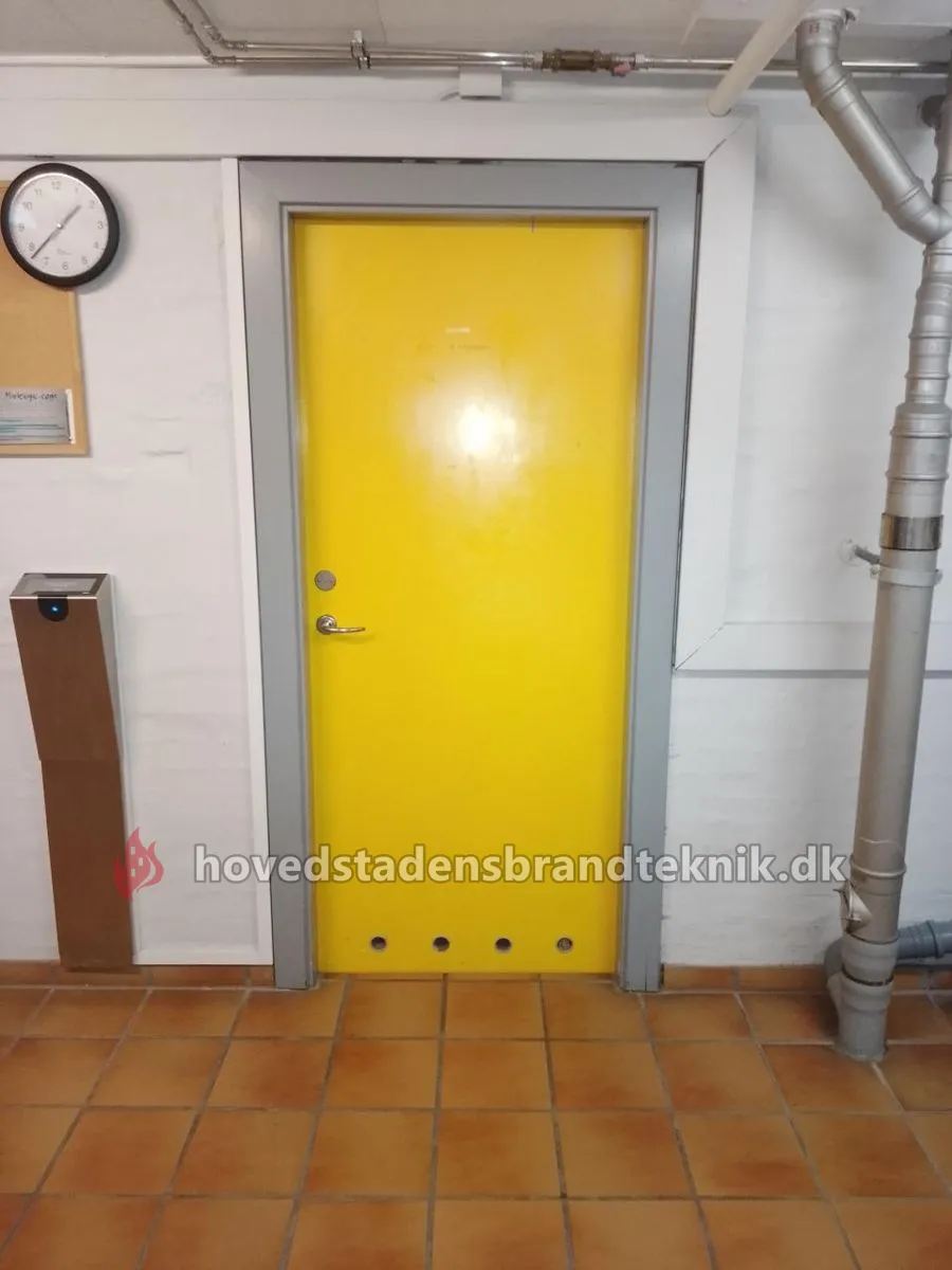 Gul dør i kælder med borede huller i bunden